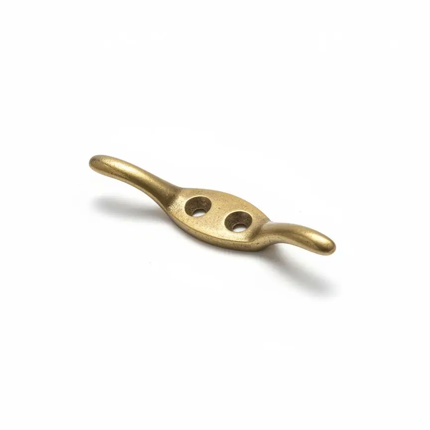A cast cord cleat fitted to the architrave of a sash window for tying off a draw cord.