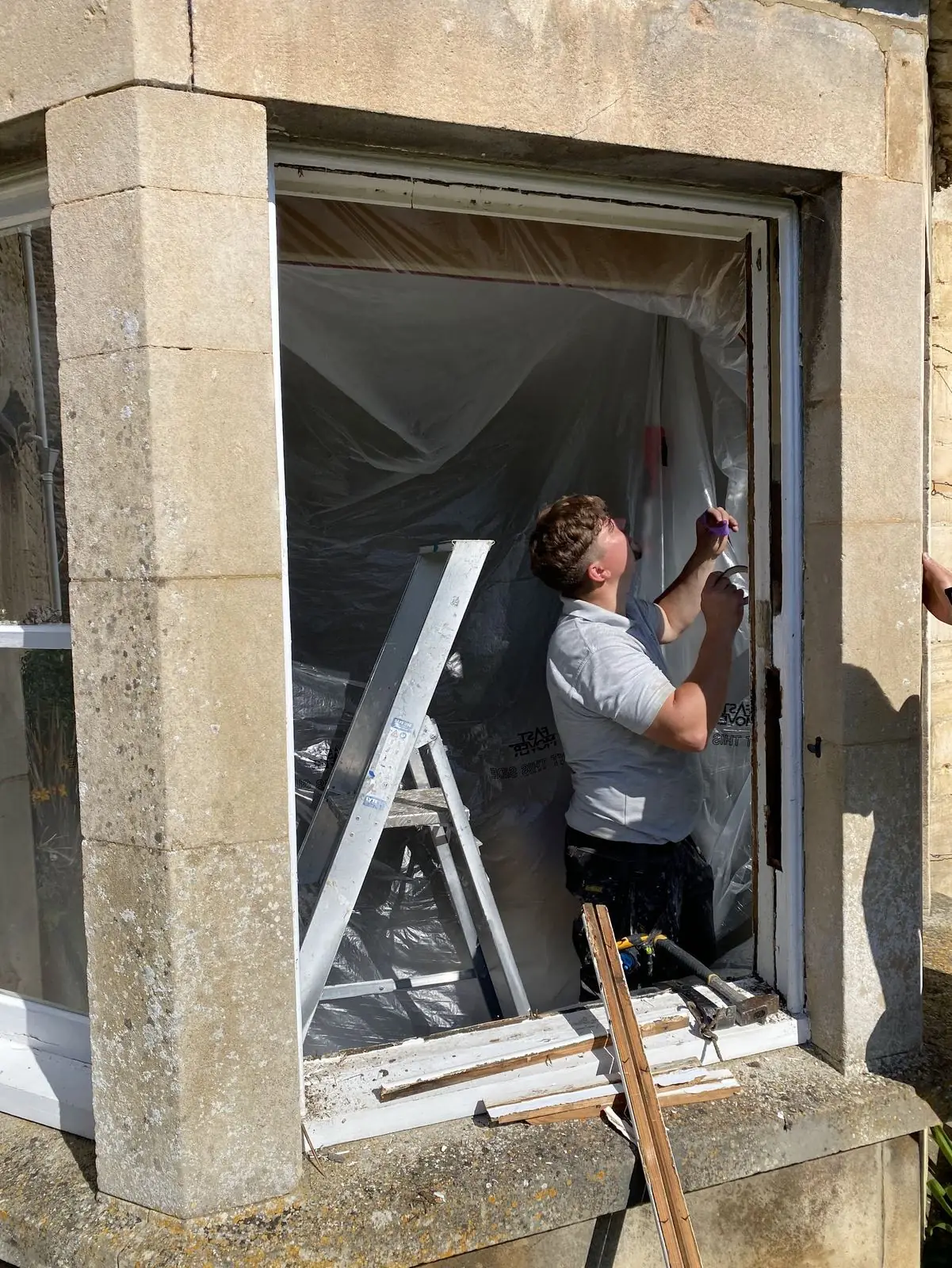 A sash window restoration in progress with the original sash removed and the cill stripped back