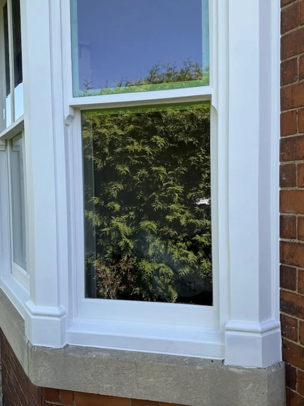 The same sash window after refurbishment — fresh white paint, clean reveal, new glazing
